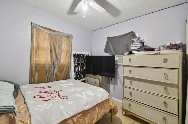 tiled bedroom featuring ceiling fan and a textured ceiling