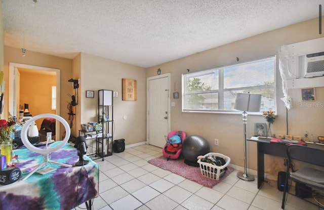 interior space featuring a wall mounted air conditioner, light tile patterned floors, and a textured ceiling