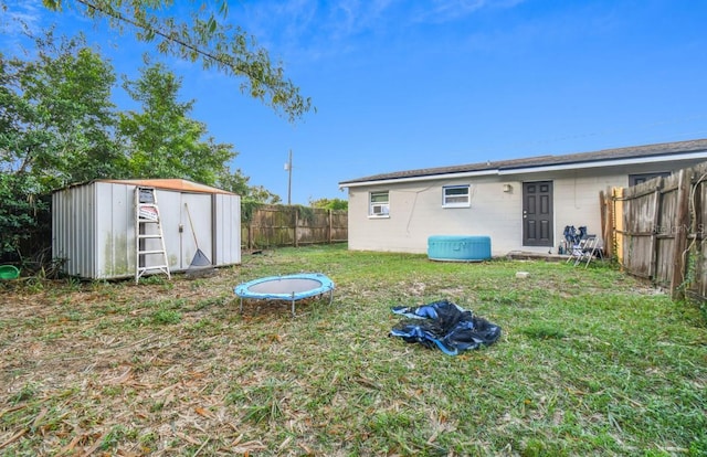 view of yard with a trampoline and a shed