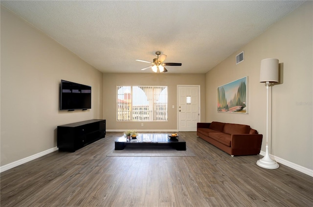 unfurnished living room featuring a textured ceiling, ceiling fan, and dark wood-type flooring