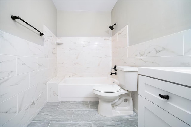 full bathroom with toilet, vanity, tiled shower / bath, tile walls, and tile flooring