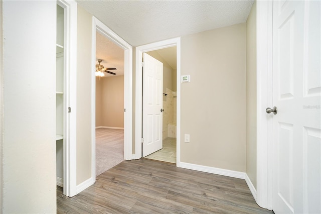 hallway with dark wood-type flooring and a textured ceiling