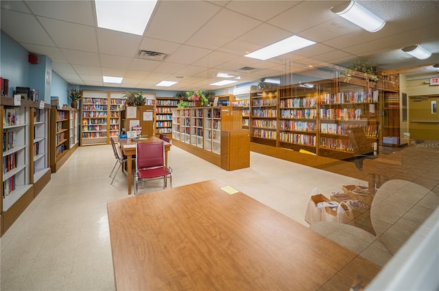 interior space with light tile floors and a paneled ceiling