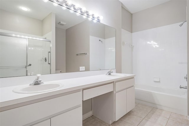 bathroom featuring tile patterned flooring, vanity, and tiled shower / bath