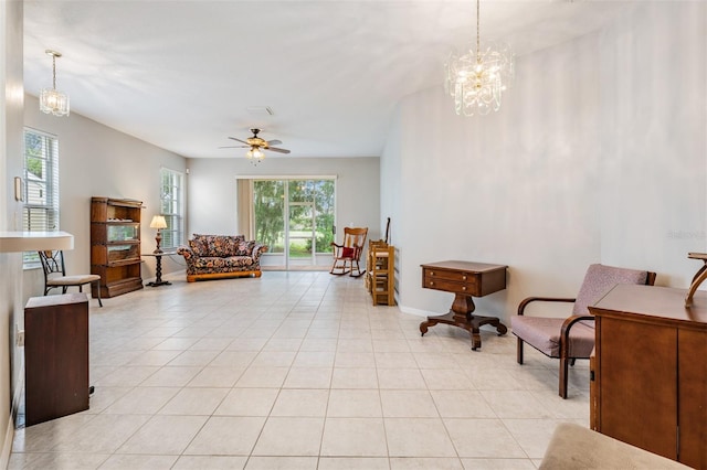 tiled living room featuring ceiling fan with notable chandelier