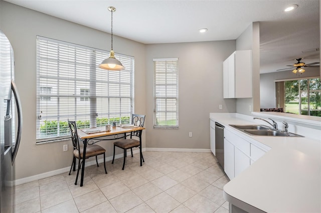 kitchen with pendant lighting, light tile patterned floors, sink, ceiling fan, and white cabinetry