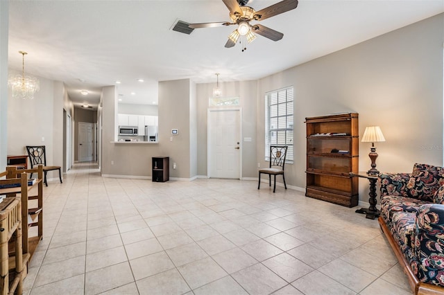 living room featuring ceiling fan with notable chandelier and light tile patterned floors