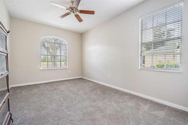 spare room featuring plenty of natural light, light carpet, and ceiling fan