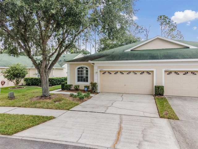 ranch-style home with a garage and a front lawn