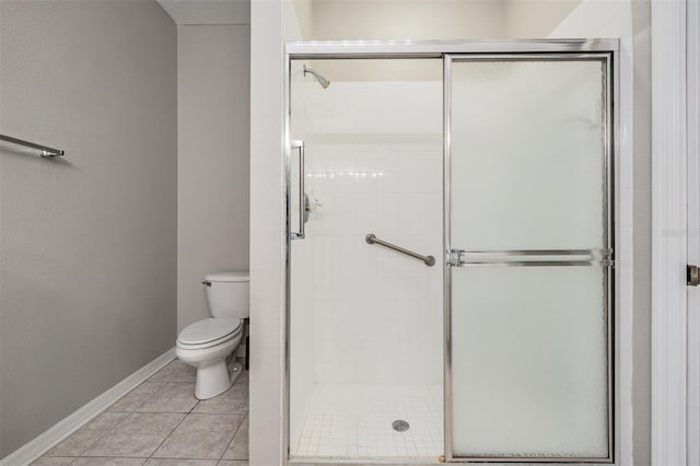 bathroom with tile patterned flooring, toilet, and an enclosed shower