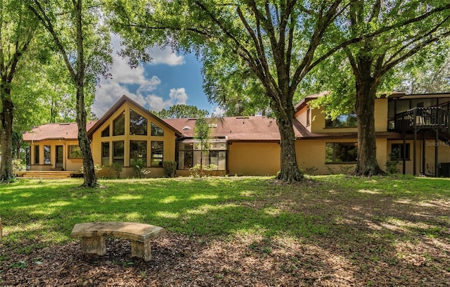 rear view of house featuring a lawn