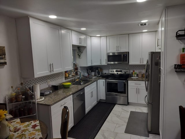 kitchen with white cabinets, stainless steel appliances, light tile floors, and sink