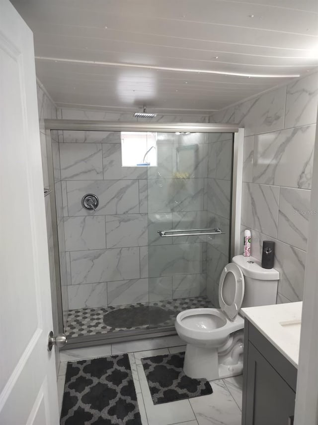 bathroom featuring toilet, a shower with door, tile flooring, and vanity