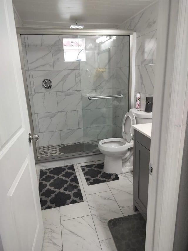 bathroom featuring vanity, tile floors, a shower with shower door, and toilet