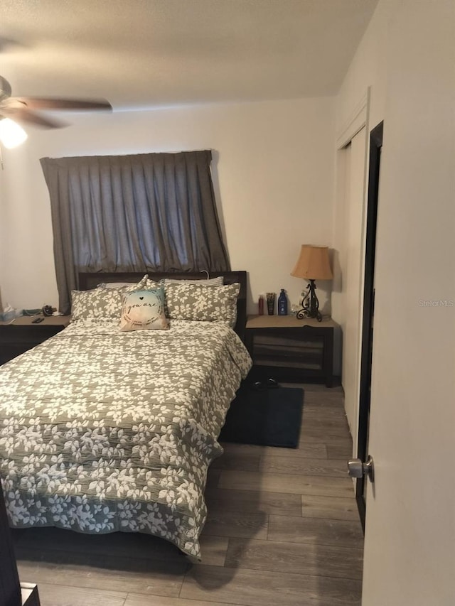 bedroom with dark hardwood / wood-style flooring and ceiling fan