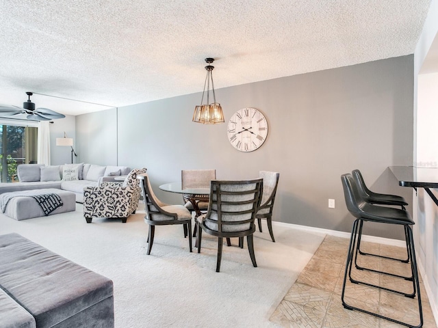 dining space with ceiling fan with notable chandelier, light colored carpet, a textured ceiling, and baseboards