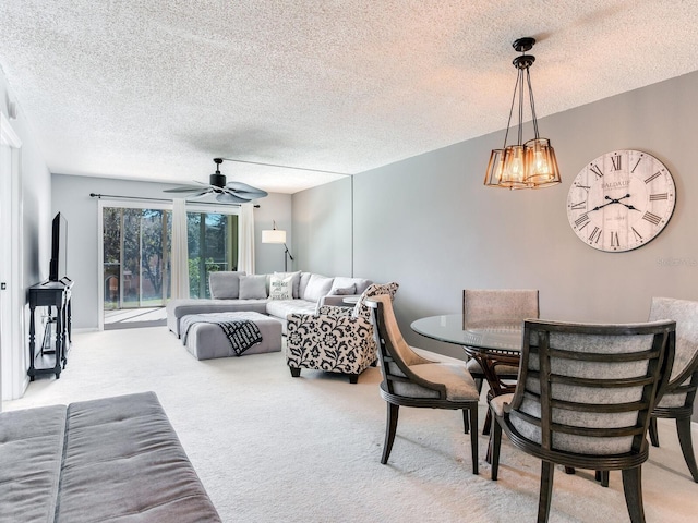 living room with a textured ceiling, light colored carpet, and ceiling fan with notable chandelier