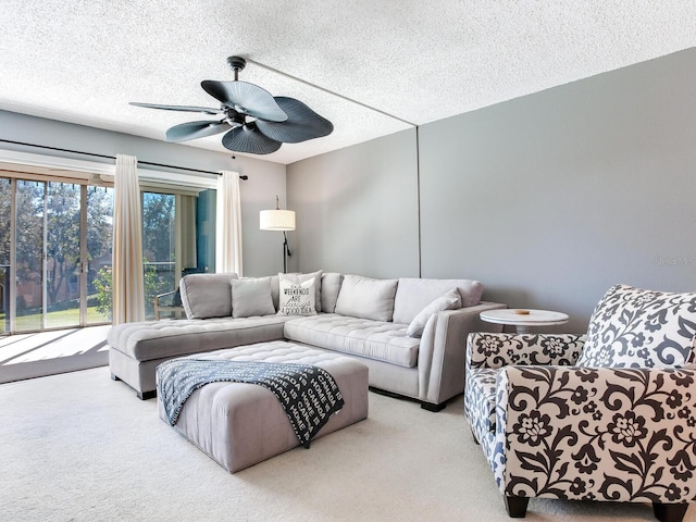 carpeted living room featuring a textured ceiling and ceiling fan