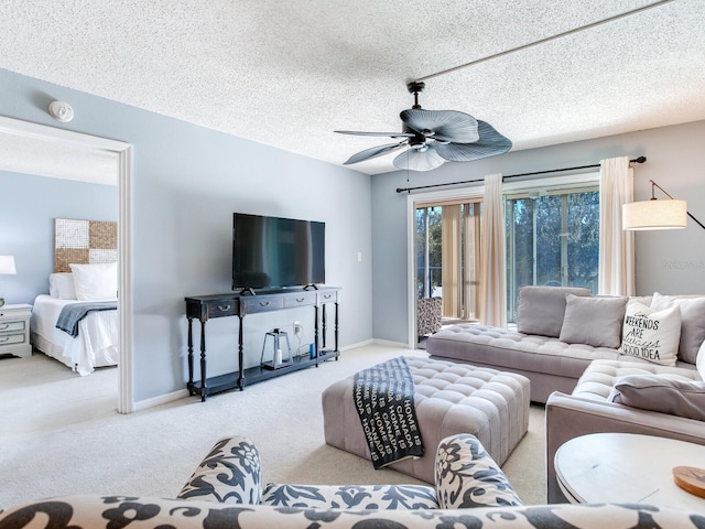 living room with ceiling fan, a textured ceiling, and light colored carpet