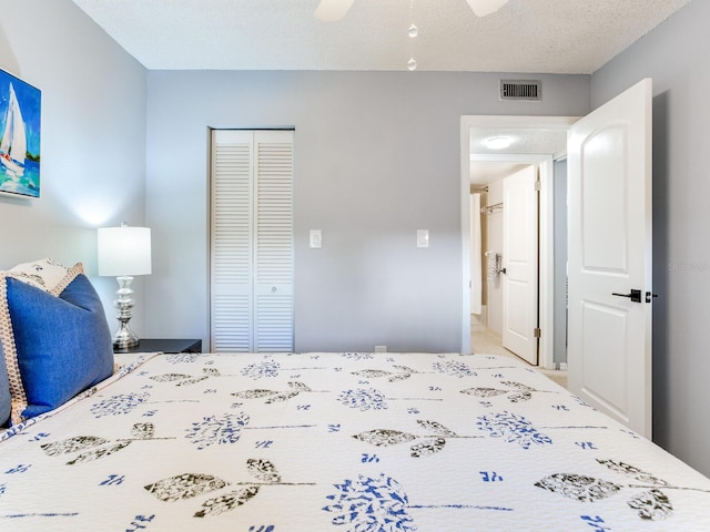 unfurnished bedroom featuring a closet, visible vents, a textured ceiling, and ceiling fan