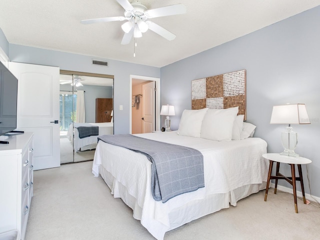 bedroom featuring visible vents, a closet, baseboards, light colored carpet, and ceiling fan