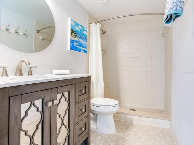 bathroom with vanity, a shower with shower curtain, toilet, and tile patterned floors