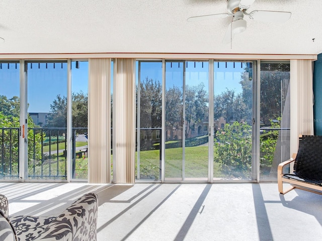 sunroom / solarium with a healthy amount of sunlight and ceiling fan