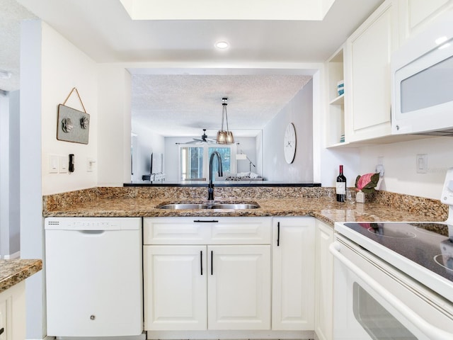 kitchen featuring sink, white cabinets, a textured ceiling, and white appliances