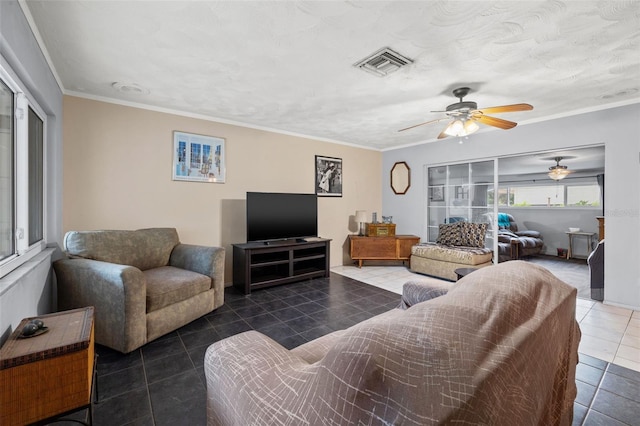 living room featuring dark tile floors, crown molding, and ceiling fan