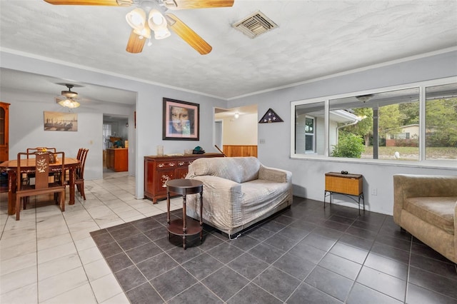 living room featuring tile floors, ceiling fan, and crown molding