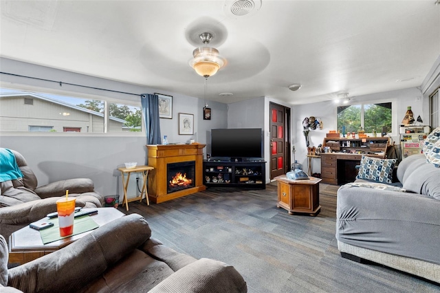 carpeted living room featuring plenty of natural light and ceiling fan