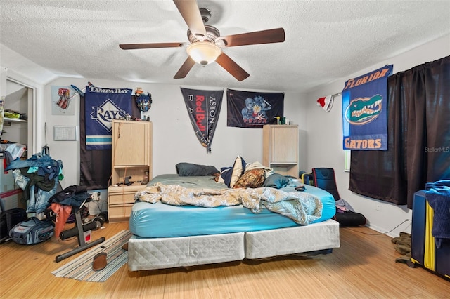 bedroom featuring a textured ceiling, ceiling fan, and light wood-type flooring