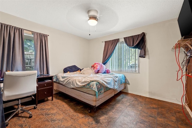 tiled bedroom with a textured ceiling and ceiling fan