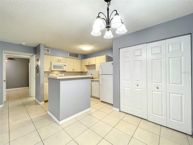 kitchen featuring white appliances, a notable chandelier, light tile flooring, and a center island