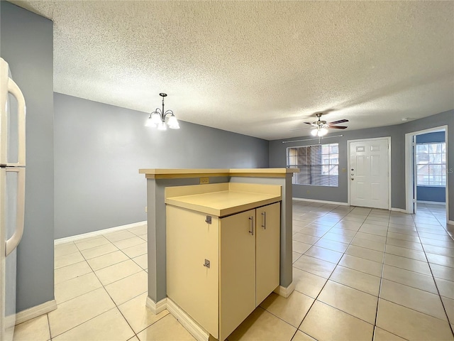 kitchen featuring hanging light fixtures, a textured ceiling, ceiling fan with notable chandelier, and light tile floors