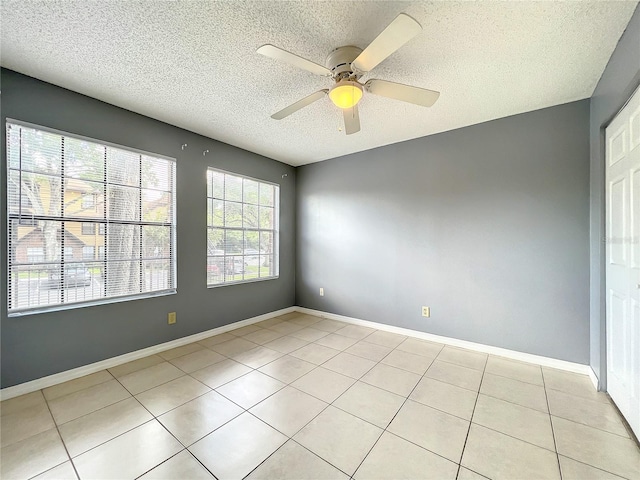 unfurnished room featuring a textured ceiling, light tile flooring, and ceiling fan