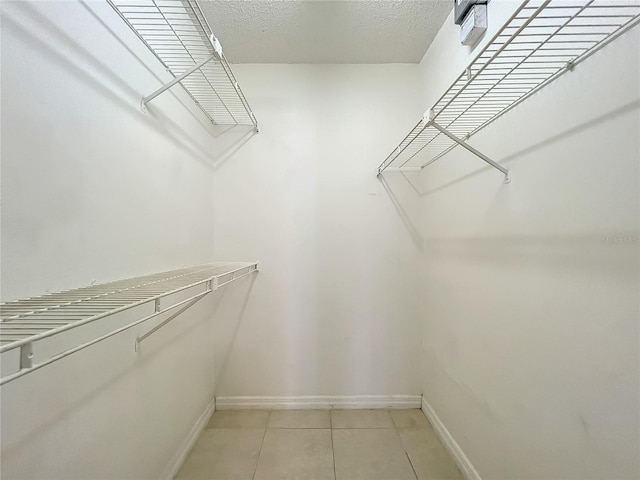 spacious closet with light tile flooring