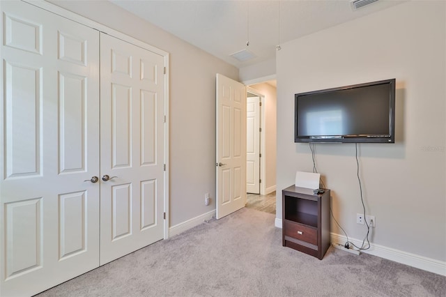 unfurnished bedroom with light carpet and a closet