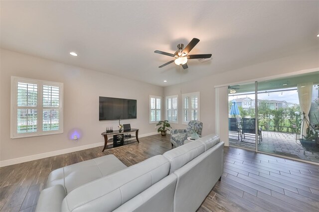 living room with ceiling fan and dark wood-type flooring