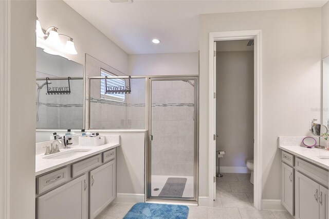 bathroom with vanity, a shower with shower door, toilet, and tile patterned floors