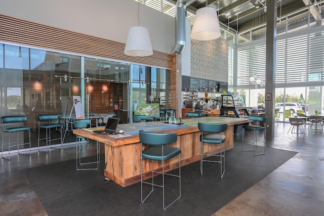 bar featuring a towering ceiling and concrete flooring