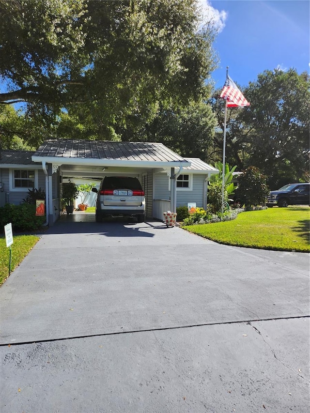 view of front of home with a front yard, a garage, and a carport