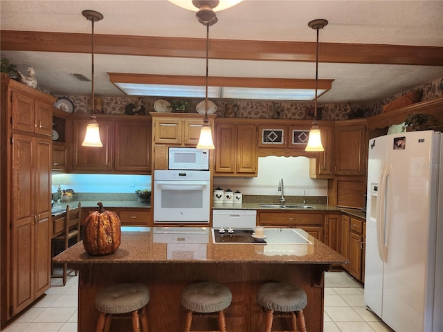 kitchen with decorative light fixtures, a center island, white appliances, and sink