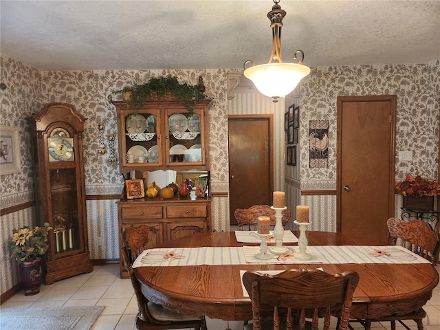 dining area featuring light tile floors and a textured ceiling