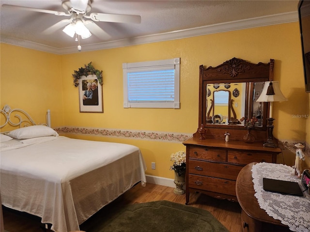 bedroom featuring ceiling fan, ornamental molding, and dark wood-type flooring