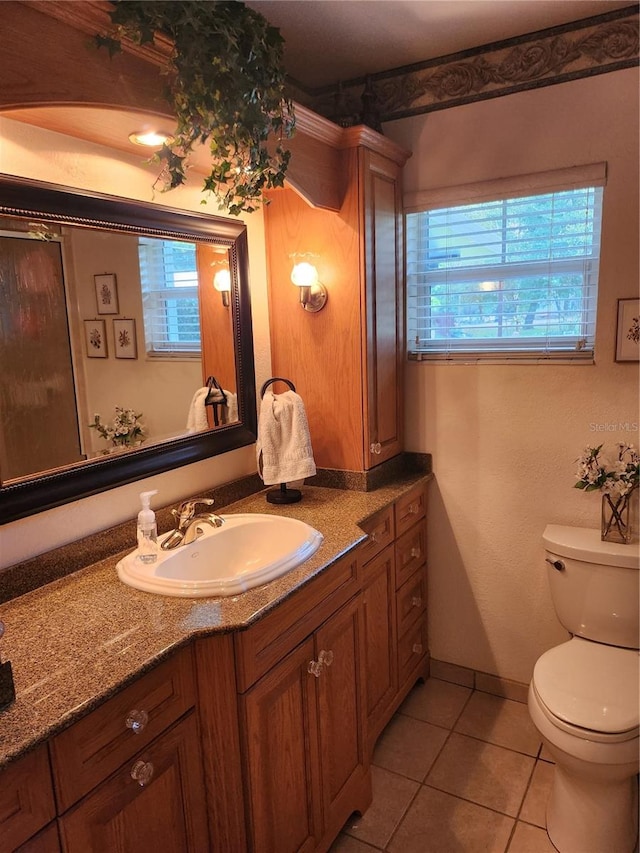 bathroom featuring toilet, tile floors, and vanity