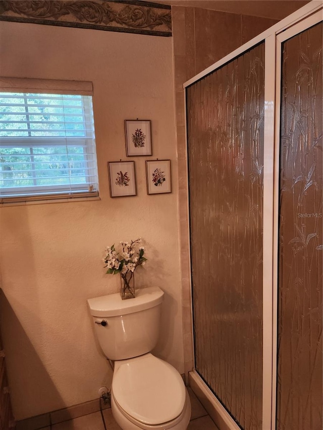 bathroom with toilet, tile floors, and an enclosed shower