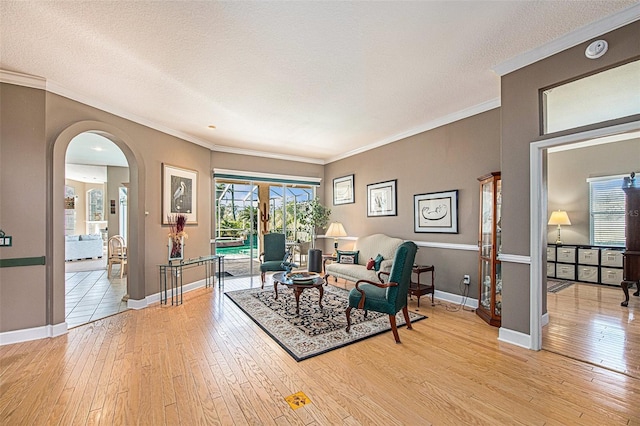 living room featuring a textured ceiling, light hardwood / wood-style floors, and ornamental molding