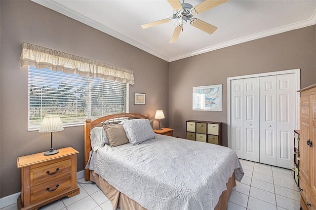 bedroom featuring light tile patterned floors, a closet, ceiling fan, and crown molding