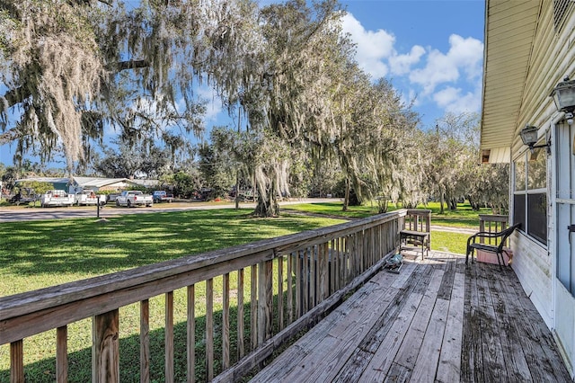 wooden deck featuring a lawn